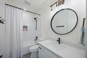 Bathroom with shower / tub combo with curtain and vanity