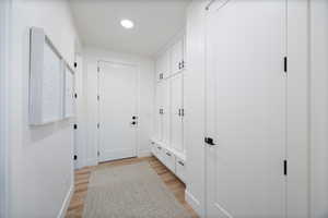 Mudroom featuring light wood finished floors and baseboards