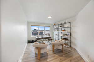 Office area featuring light wood-style flooring and a textured ceiling