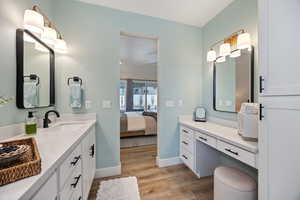 Ensuite bathroom featuring vanity and light wood-type flooring