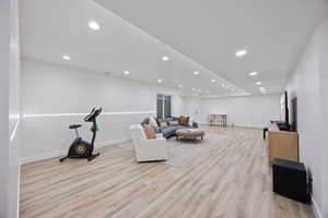 Living room with light wood-style flooring and recessed lighting