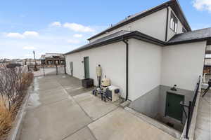 View of home's exterior featuring stucco siding, a gate, and a patio