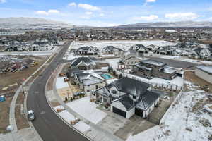 Snowy aerial view featuring a residential view and a mountain view