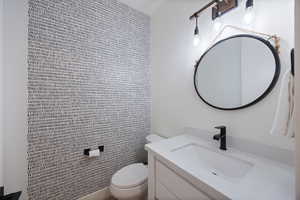 Half bathroom with vanity and toilet