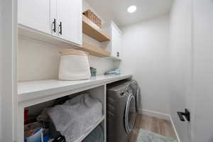 Laundry area featuring light wood-type flooring, cabinet space, independent washer and dryer, and recessed lighting