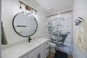 Bathroom featuring vanity, shower / bathtub combination with curtain, and light wood finished floors