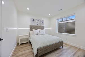 Bedroom with light wood-type flooring and recessed lighting