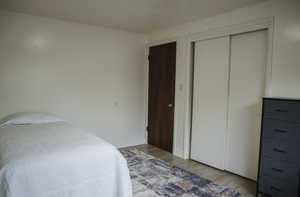 Bedroom featuring light, LVP flooring and a closet