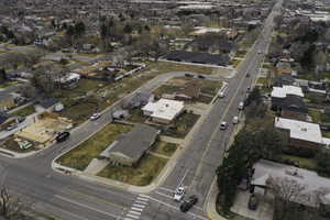 Aerial view of property and surrounding area with nearby suburban area