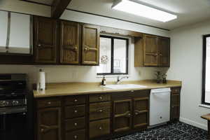 Kitchen with stainless steel gas range oven, light countertops, white dishwasher, and exhaust hood