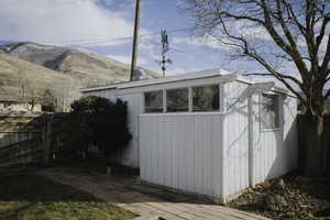 View of outbuilding featuring a fenced backyard and a mountain view