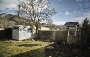 Fenced backyard with an outbuilding and a mountain view
