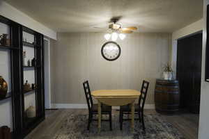 Dining area with ceiling fan, a textured ceiling, and LVP flooring,