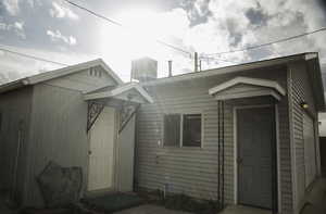 View of shed and man door entrance to detached two-car garage.