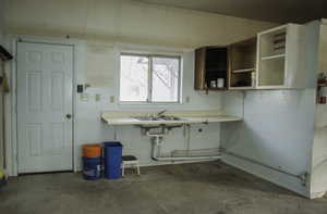 Garage with concrete flooring, light countertops, and open shelves