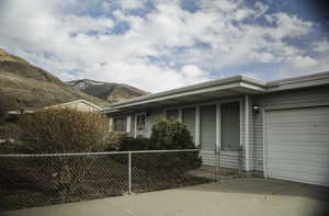 View of property exterior with an attached single-car garage, a mountain view, and driveway
