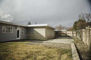 Back of house with a fenced backyard, brick masonry and aluminum siding, a gate, and a patio