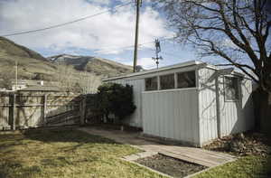 Shed featuring a fenced backyard and a mountain view