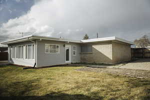Rear view of property featuring brick masonry and aluminum siding.