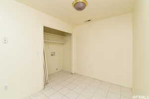 Laundry area with light tile patterned floors and baseboards