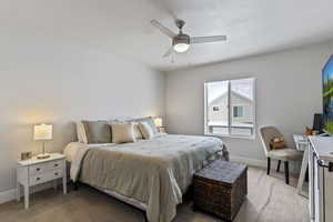 Bedroom with light carpet and a ceiling fan