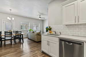 Kitchen featuring dishwasher, white cabinetry, dark wood finished floors, and a textured ceiling