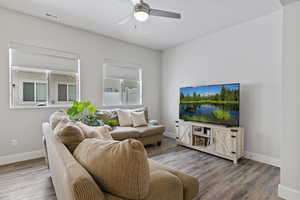 Living room with light wood-type flooring and ceiling fan