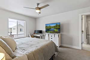 Bedroom featuring carpet floors, ceiling fan, and ensuite bathroom