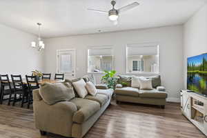 Living room featuring wood finished floors, ceiling fan, and hanging lights