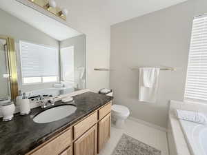 Master bathroom featuring a bath, vanity, lofted ceiling, garden tub and seperate glass enclosed shower.