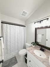 Bathroom with vanity, a shower, and lofted ceiling