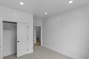 Unfurnished bedroom with a closet, carpet floors, and recessed lighting