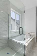 Bathroom with a bath and a marble finish shower