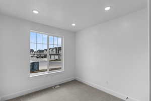 Carpeted spare room featuring baseboards and recessed lighting