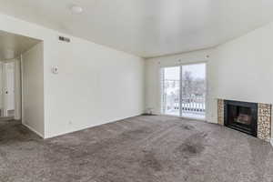 Unfurnished living room with a fireplace and carpet floors