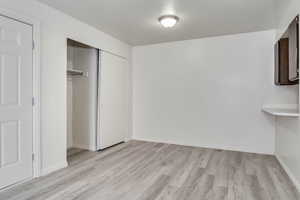 Unfurnished bedroom with light wood-style floors and a closet
