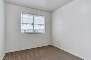 Empty room with carpet floors and baseboards