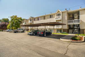View of property with covered and uncovered parking