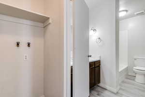 Bathroom featuring vanity, light wood finished floors, and tub / shower combination