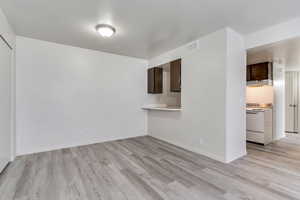 Unfurnished living room with light wood-style floors and baseboards
