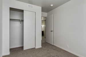 Unfurnished bedroom featuring carpet flooring and a closet