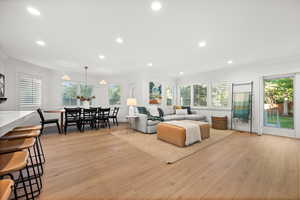 Living area with light wood-style flooring, recessed lighting, and ornamental molding