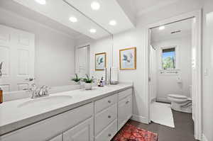 Full bathroom featuring crown molding, a shower with shower curtain, double vanity, and recessed lighting