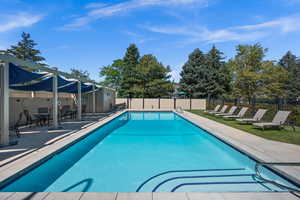 Community pool with a patio and outdoor dining space