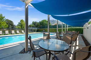 View of swimming pool featuring patio surround, outdoor dining space, and a mountain view