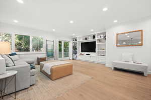Living area featuring ornamental molding, built in features, recessed lighting, and light wood finished floors