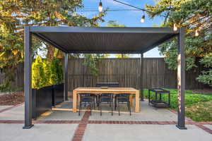 Fenced backyard featuring outdoor dining area and a patio