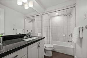 Full bathroom with vanity, shower / bath combination with curtain, and wood tiled floors