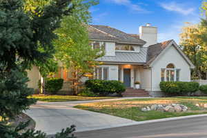 View of front of home featuring a front lawn, brick siding, and a chimney