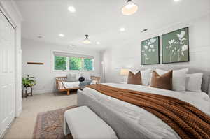 Carpeted bedroom with wainscoting, recessed lighting, a closet, ornamental molding, and wooden walls